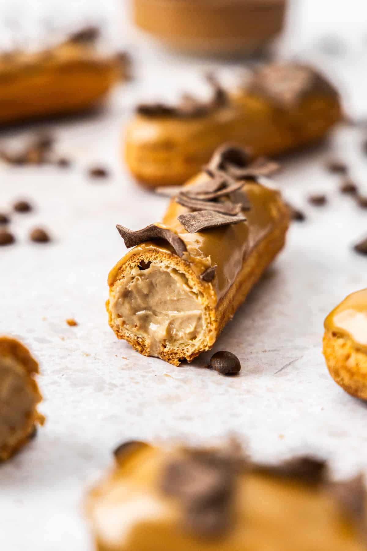 A coffee eclair cut open to show the coffee pastry cream inside.