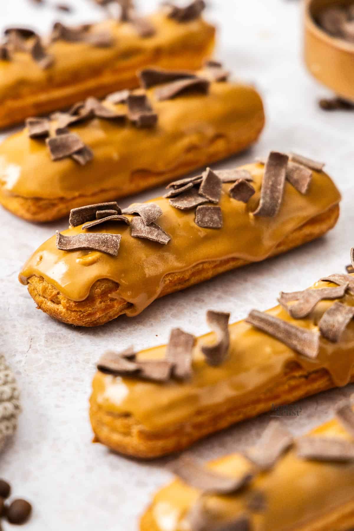 Closeup of a coffee eclair with 4 more surrounding it.
