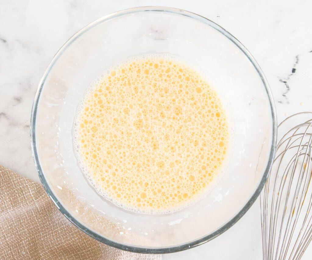 Egg yolks, milk and cornflour mixed in a bowl.