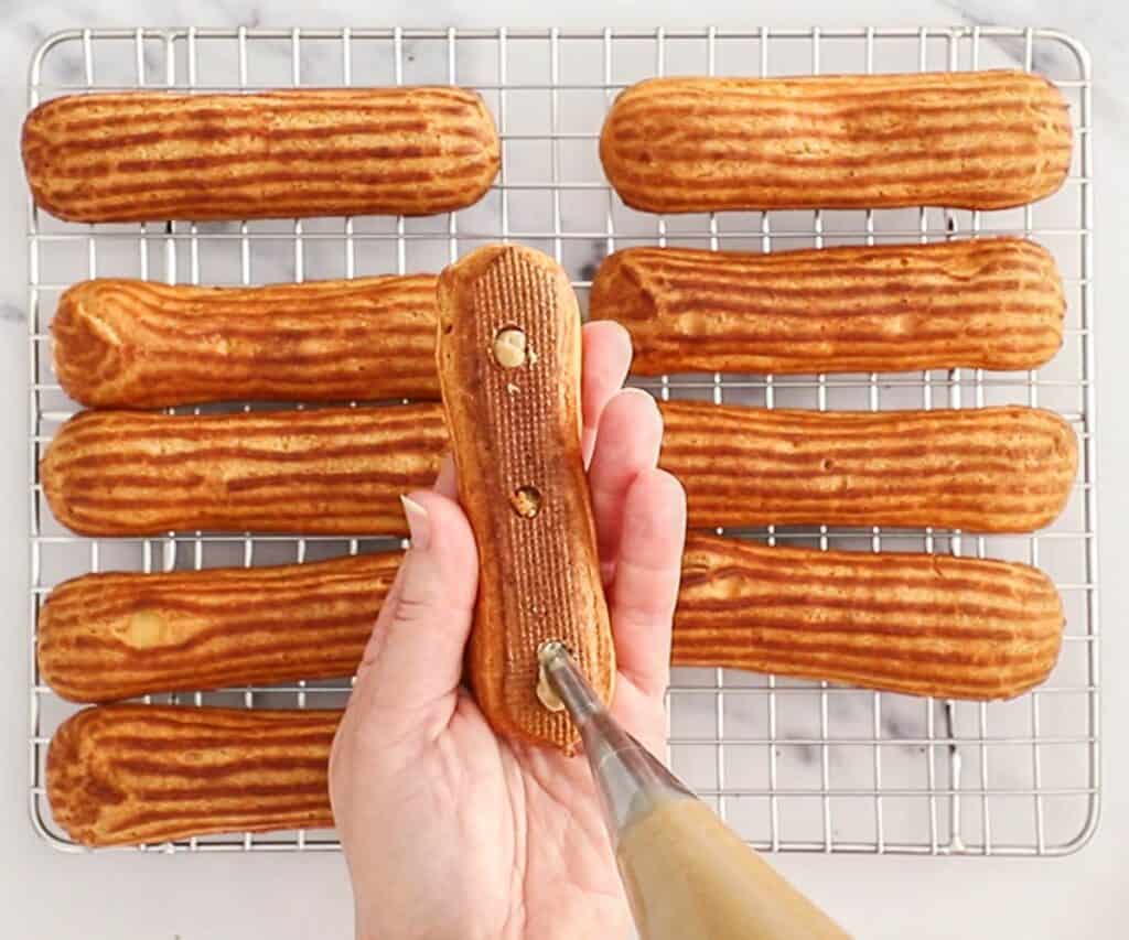 Filling the eclairs with coffee pastry cream.