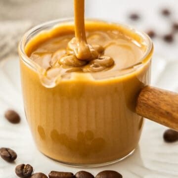 Extreme closeup of coffee glaze being drizzled into a glass.
