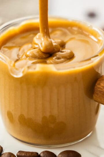Extreme closeup of coffee glaze being drizzled into a glass.