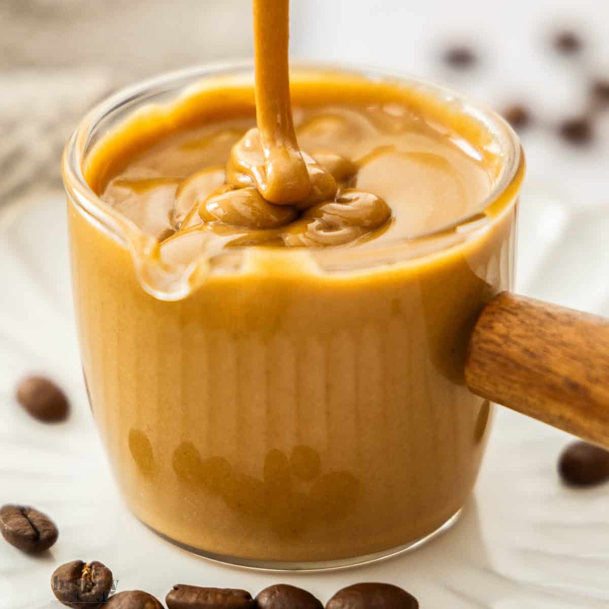 Extreme closeup of coffee glaze being drizzled into a glass.