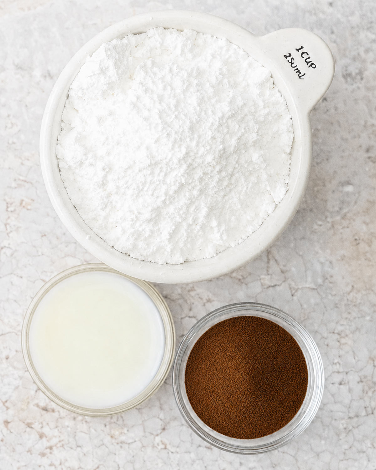 Ingredients for coffee glaze on a stone surface.
