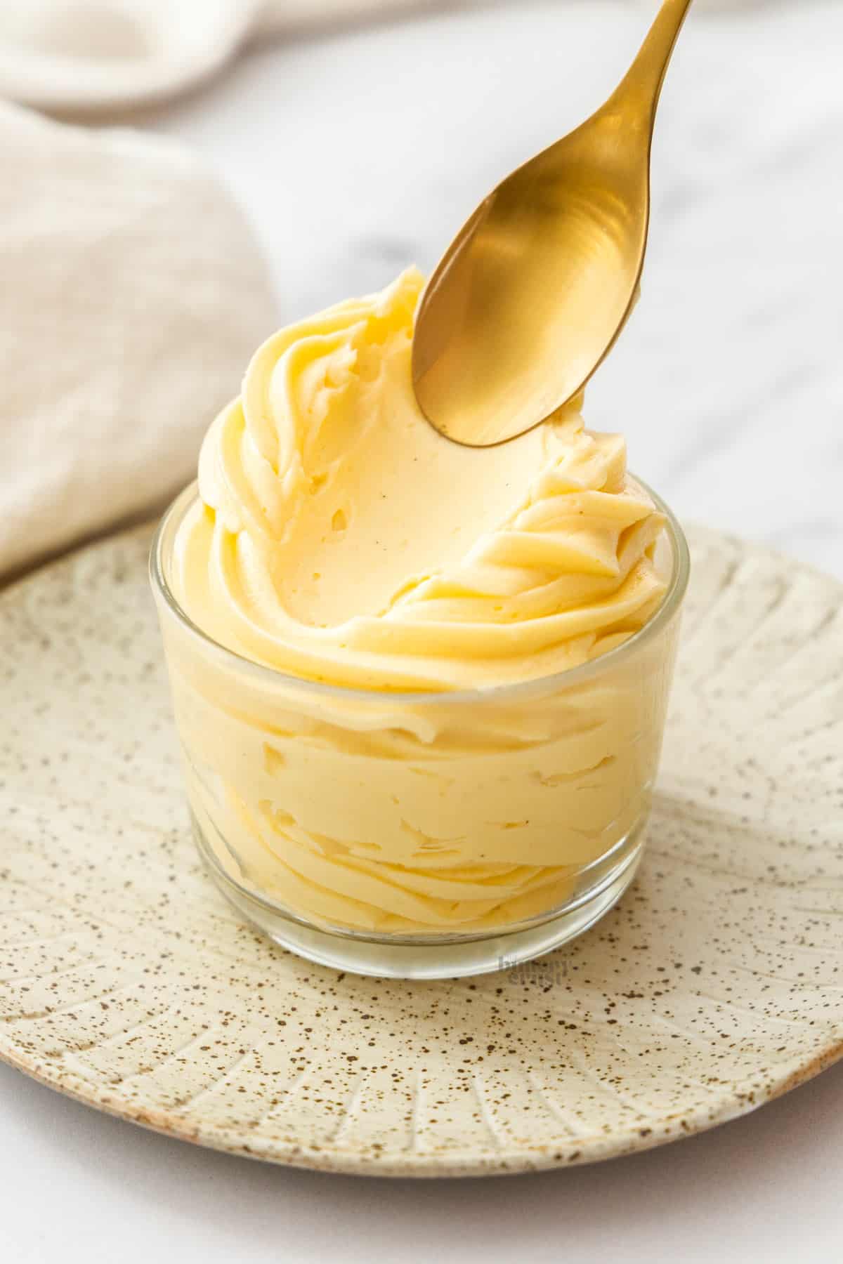 A spoon dragging through mousseline cream to show how smooth it is.