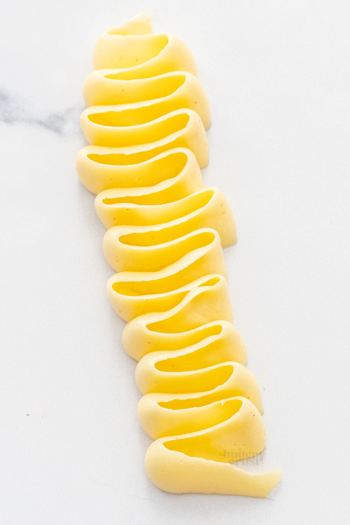 A piped swirl of mousseline cream on a marble surface.
