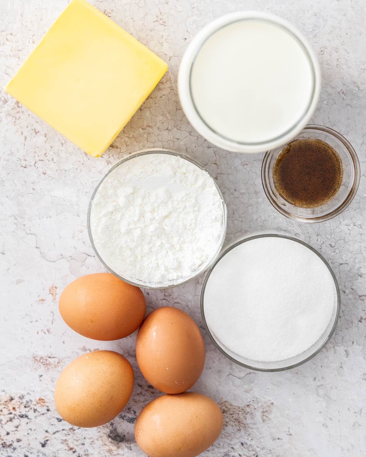 Ingredients for creme mousseline on a concrete surface.