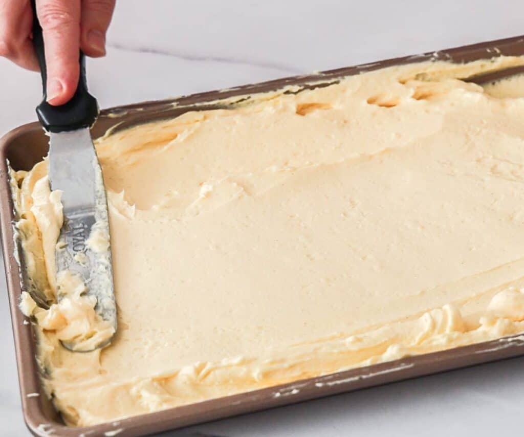 A spatula spreading mousseline cream to remove air bubbles.