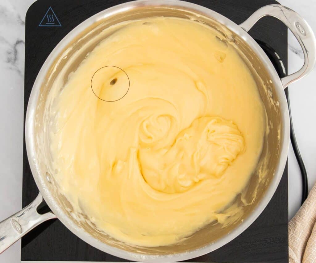 A pan of thick pastry cream showing bubbles.