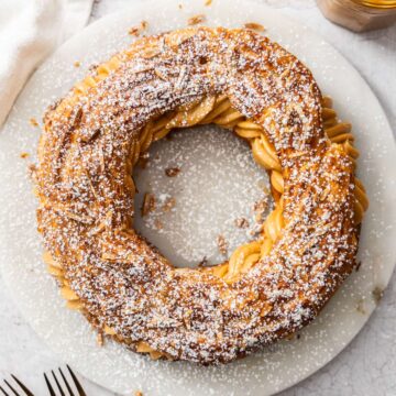Top down view of a whole Paris Brest on a marble platter.