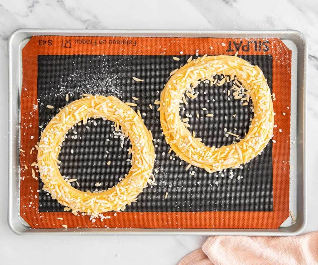 The rings of dough covered in pearl sugar and almonds.
