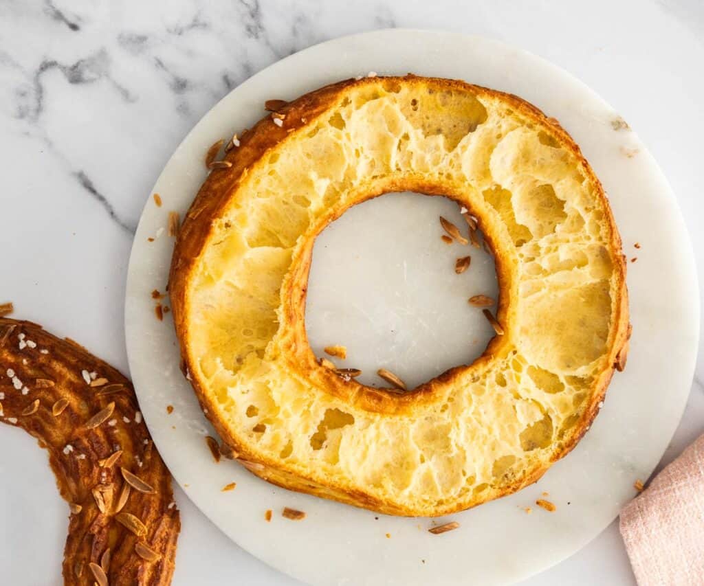 A baked chou ring sliced in half to show the hollow inside.