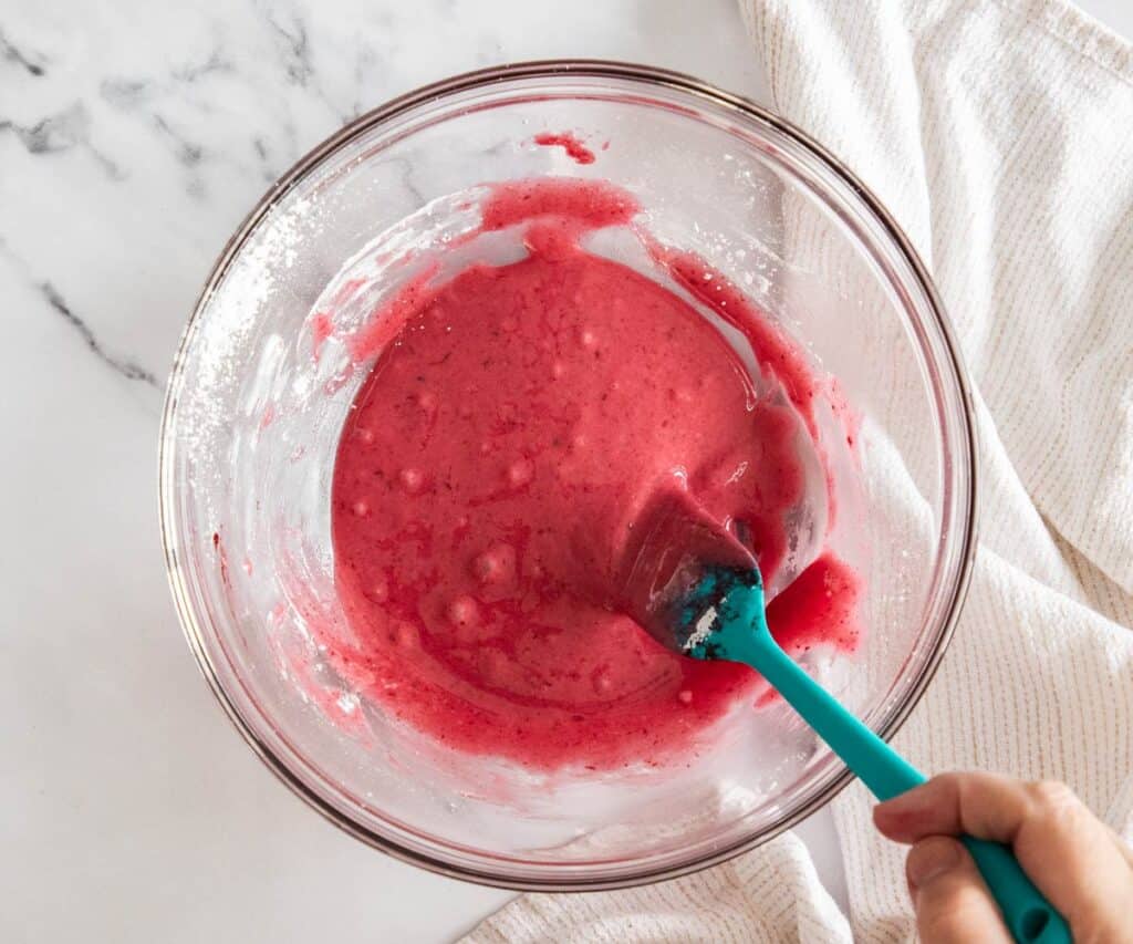 Blackberry glaze being mixed in a glass bowl.