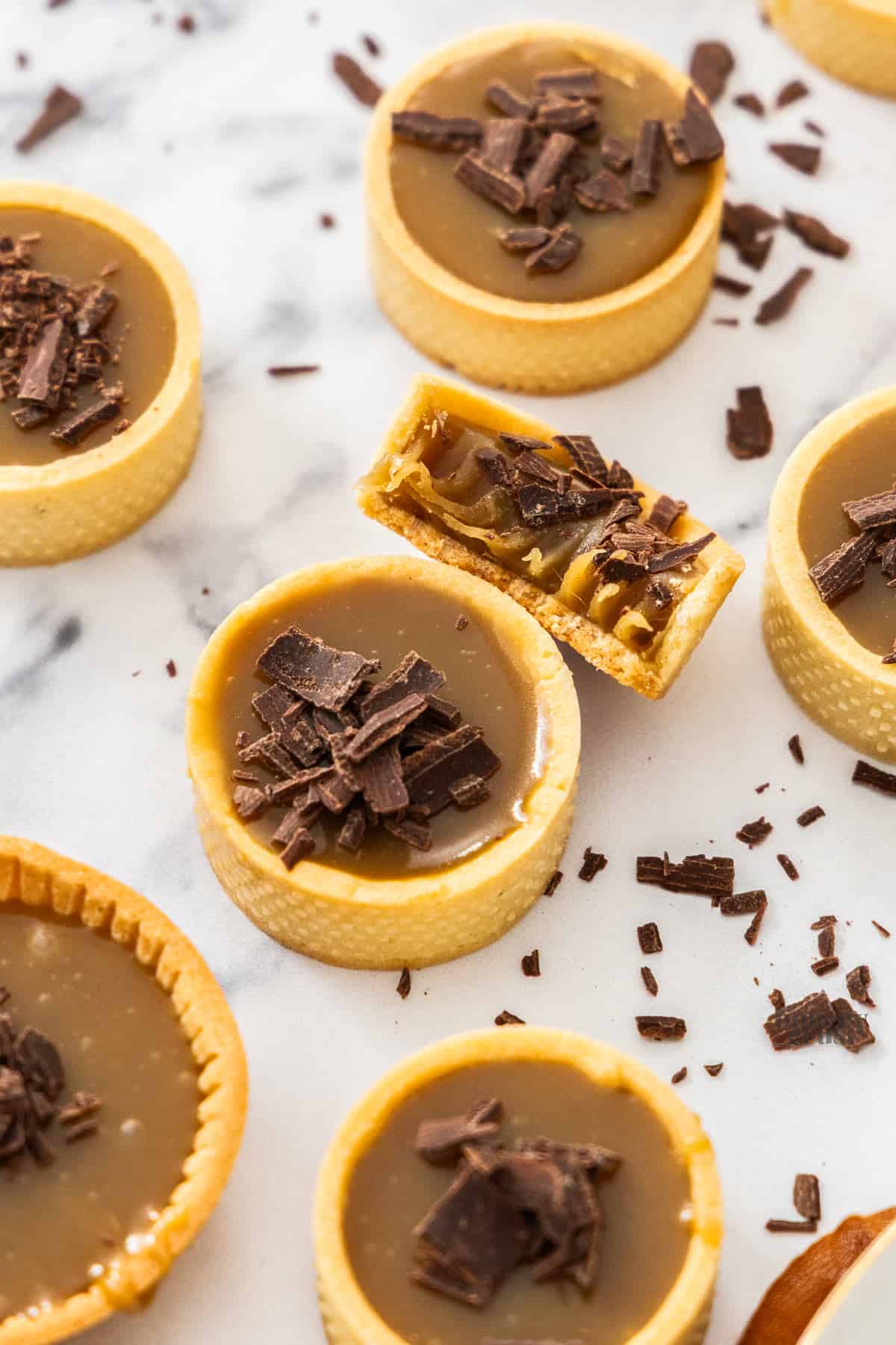 Top down view of a butterscotch tartlet with one broken open to show the butterscotch texture.