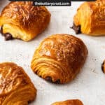 A batch of pain au chocolate on a concrete surface.