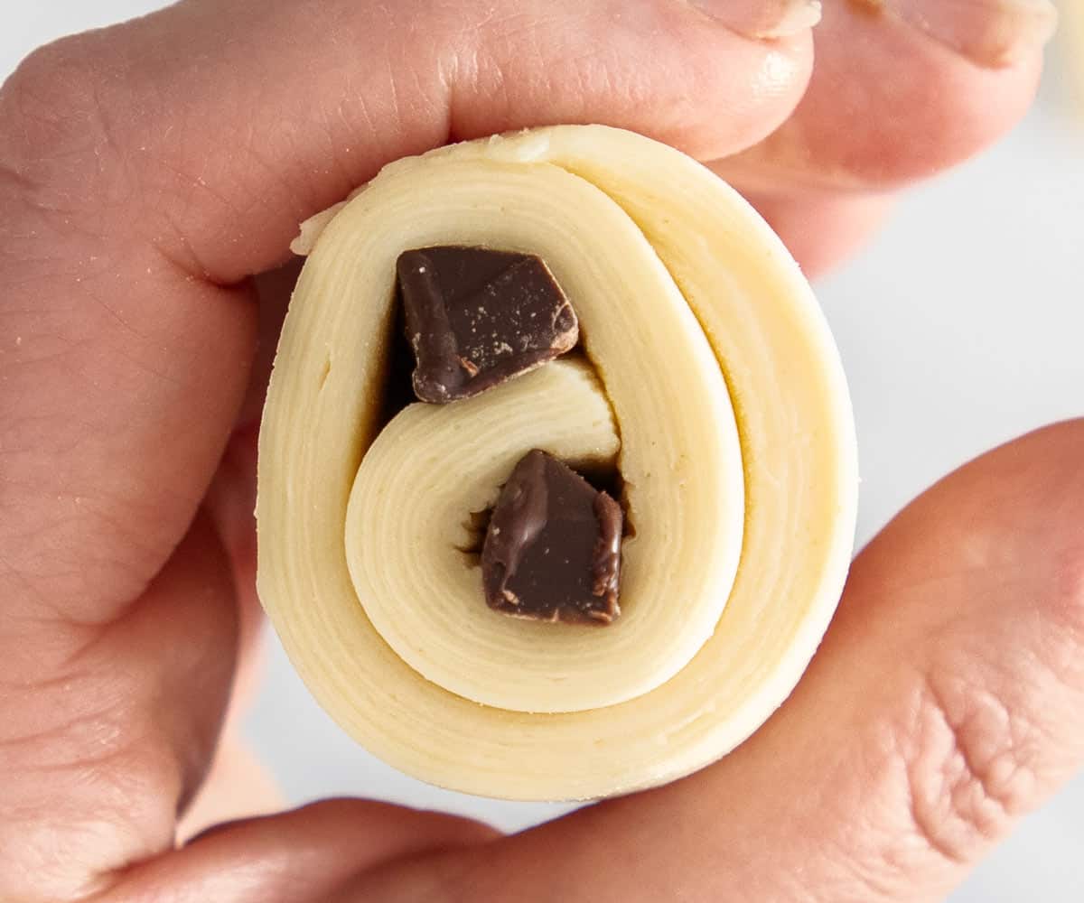 The end of a raw chocolate croissant showing the layers in the dough.
