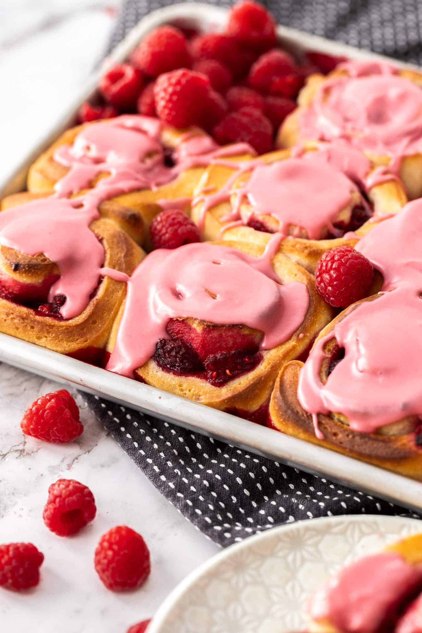 A batch of raspberry rolls, topped with raspberry icing.