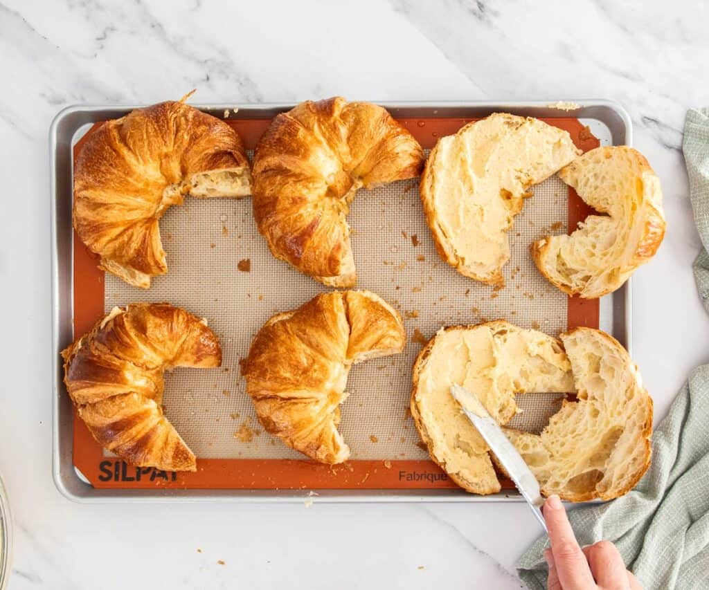 Spreading the filling on the croissants.