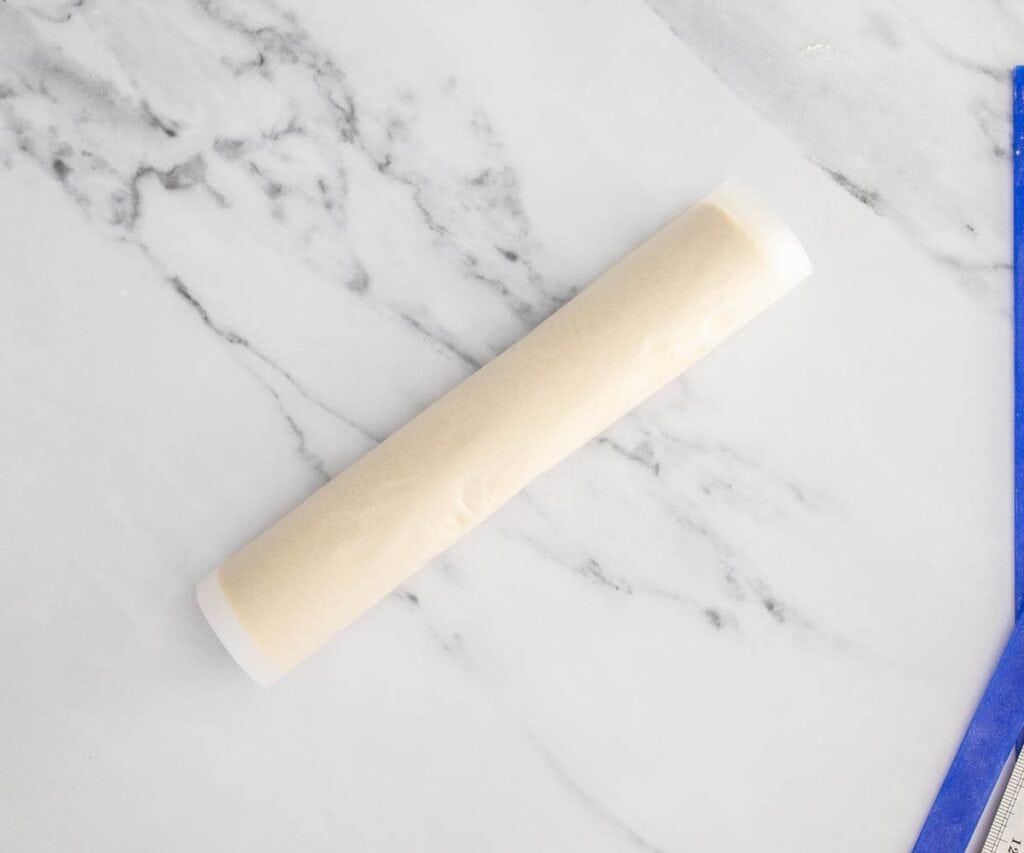 A roll of puff pastry rolled in baking paper.