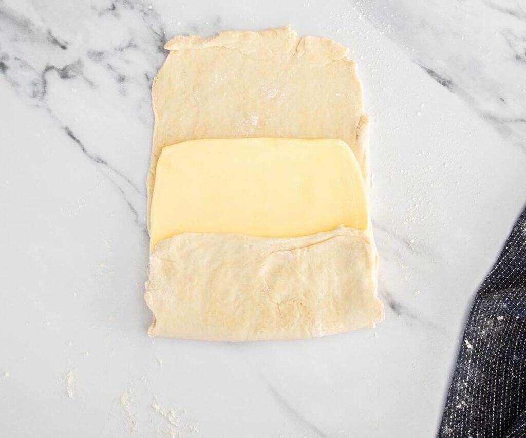 Butter with one side of dough folded over it.