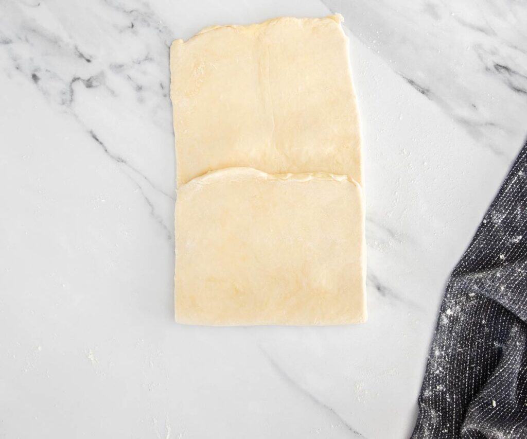The rolled out dough with one end folded up over the centre.