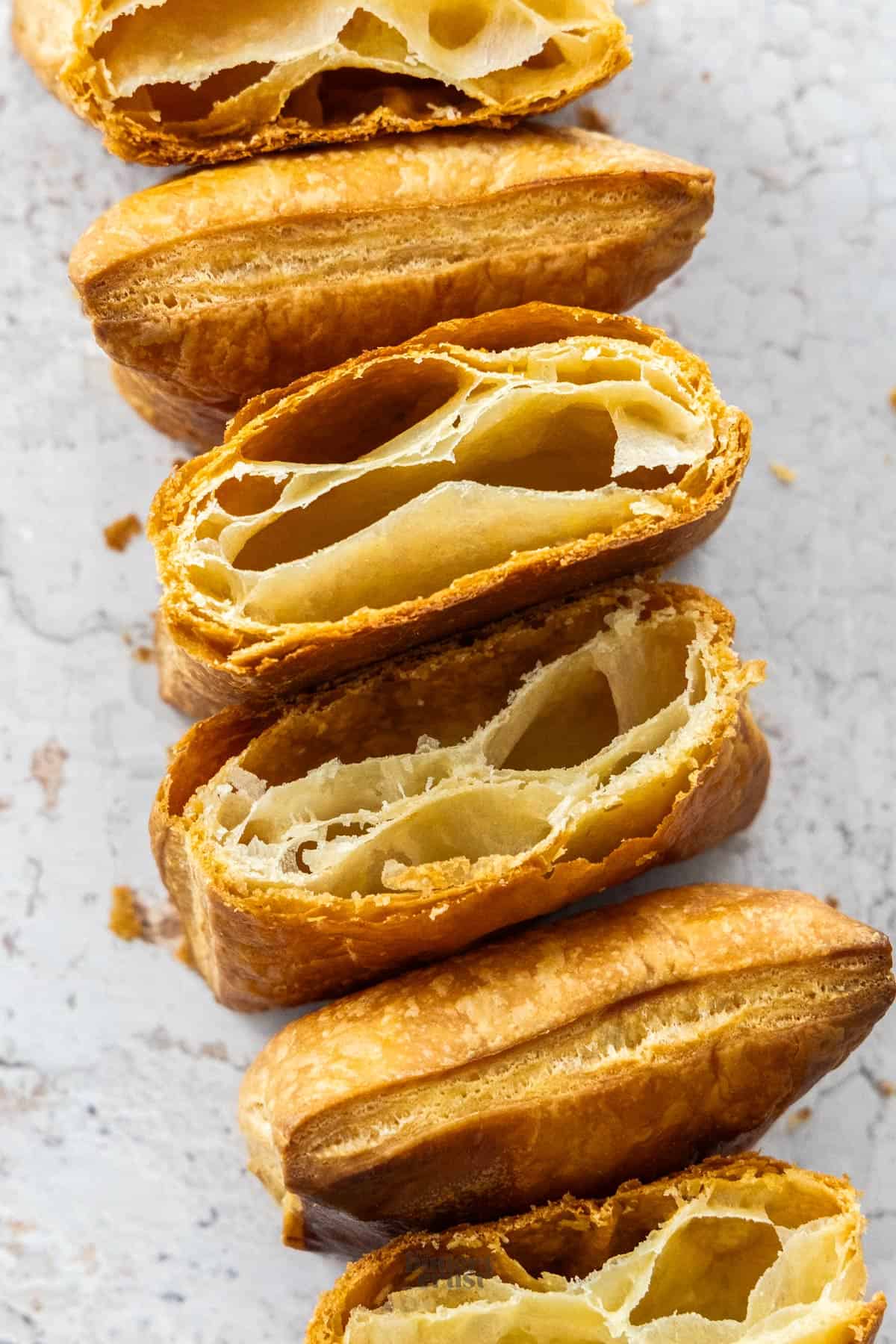Top down view of pieces of rough puff pastry cut to show the layers.