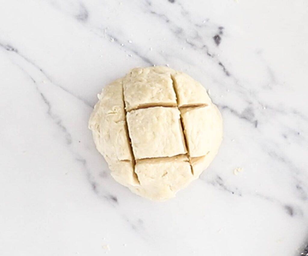 A ball of dough cut with a cross-hatch pattern.