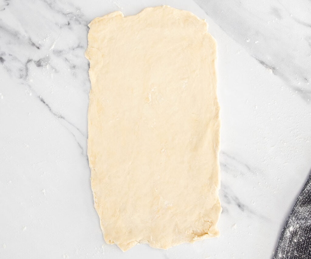 Pastry dough rolled out into a rough rectangle.